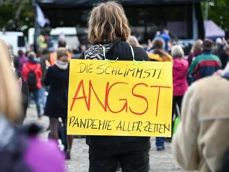 Angst sei die schlimmste Pandemie aller Zeiten, meint dieser Demonstrant bei einem Gottesdienst am Ufer des Bodensees.