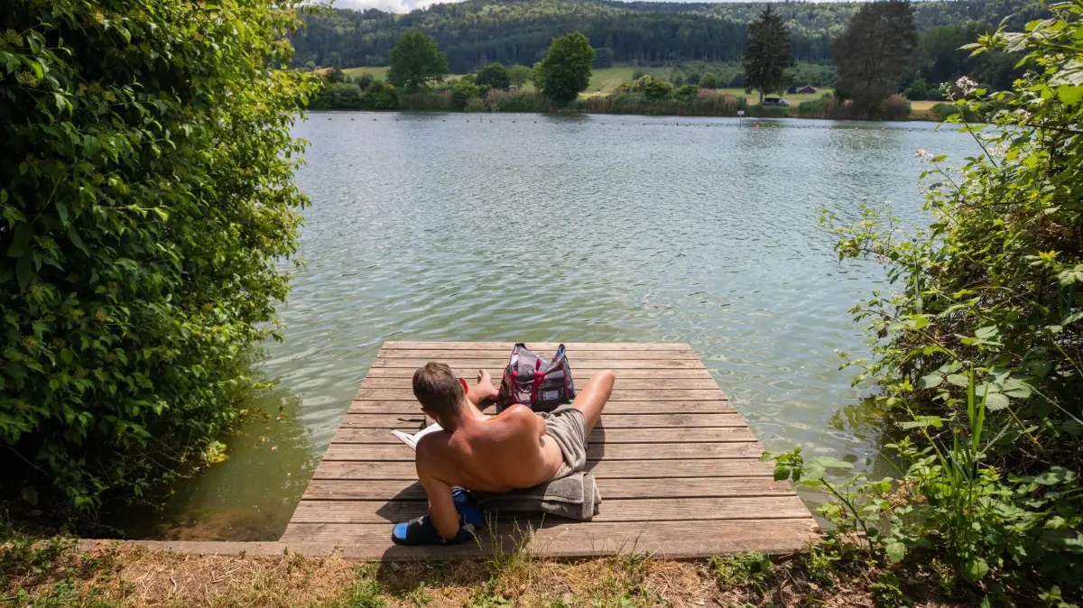 Das Wetter lädt zum Sonne-Genießen ein, hier am Badesee Plüderhausen.
09.06.2023, Baden-Württemberg, Plüderhausen: Ein Mann genießt die Sonne am Badesee Plüderhausen und liest dabei ein Buch. Weiterhin sonnig und trocken bleibt es in der Region in den nächsten Tagen. Foto: Christoph Schmidt/dpa +++ dpa-Bildfunk +++