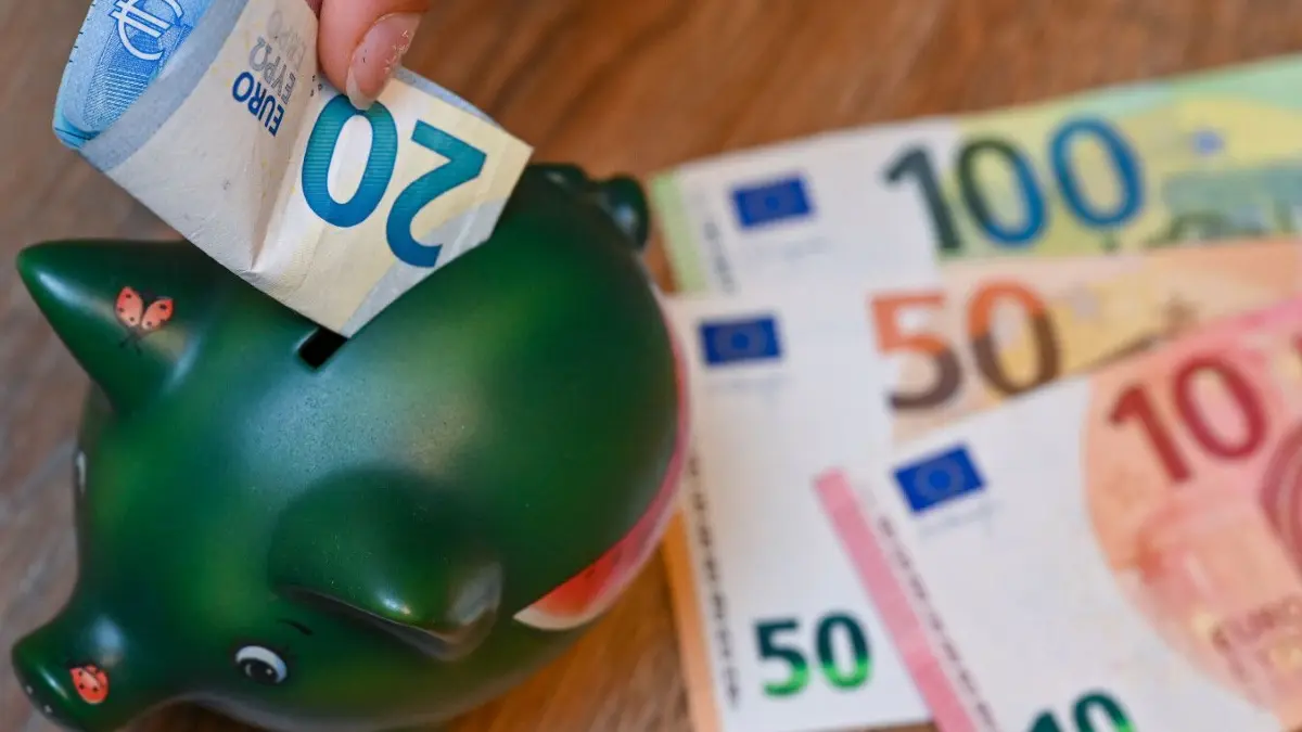 Das Sparschwein ist ein schlechter Aufbewahrungsort für höhere Geldbeträge. Denn einige Banken geben wieder ordentlich Zinsen aufs Festgeld.
PRODUKTION - 05.10.2021, Brandenburg, Sieversdorf: ILLUSTRATION: Ein Mädchen steckt einen 20-Euro-Schein in ein Sparschwein (gestellte Aufnahme). Am 07.10.2021 wird die Vermögensstudie der Allianz: «Allianz Global Wealth Report 2021» vorgestellt. Die Allianz berücksichtig in ihren Berechnungen in der Regel Bargeld, Bankeinlagen, Wertpapiere sowie Ansprüche gegenüber Versicherungen und Pensionsfonds, nicht jedoch Immobilien. Foto: Patrick Pleul/dpa-Zentralbild/dpa +++ dpa-Bildfunk +++