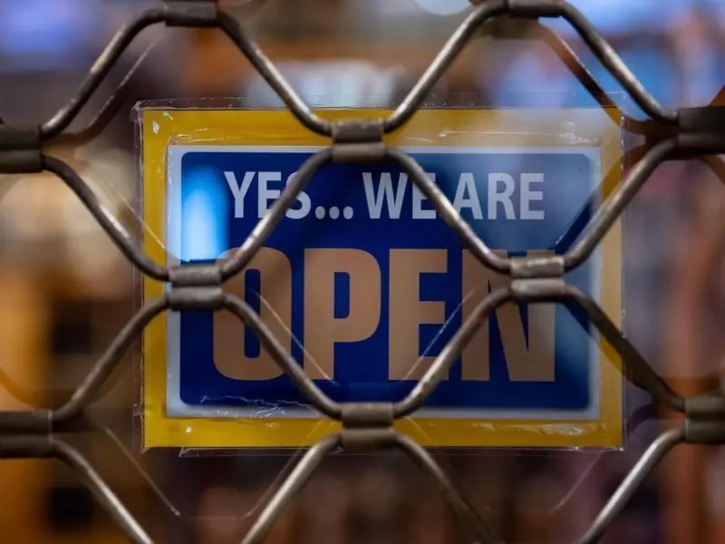 Ein Schild mit der Aufschrift „Yes... we are Open“ ist an einem geschlossenen Geschäft in München zu sehen. Foto: Sven Hoppe/dpa