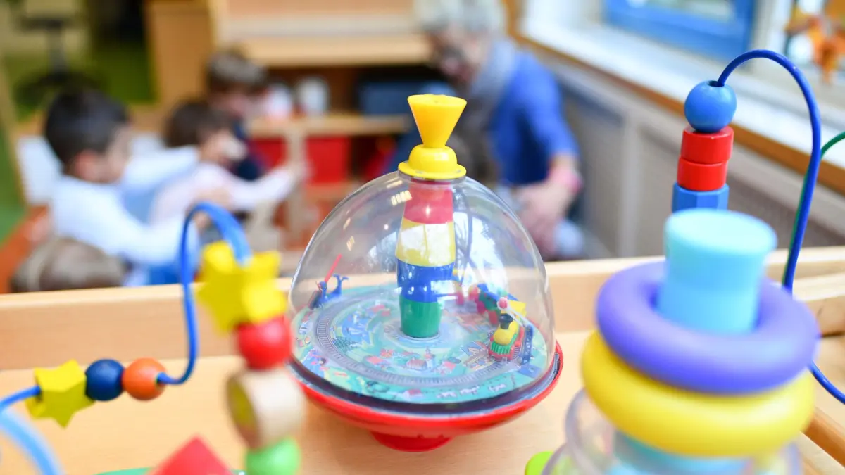 ARCHIV - 20.10.2017, Baden-Württemberg, Mannheim: Eine Erzieherin spielt in einer Kita mit Kindern. Im Vordergrund steht Spielzeug. (zu dpa: «Nur wenige Anträge zur Absenkung von Standards in Kitas gestellt») Foto: Uwe Anspach/dpa +++ dpa-Bildfunk +++