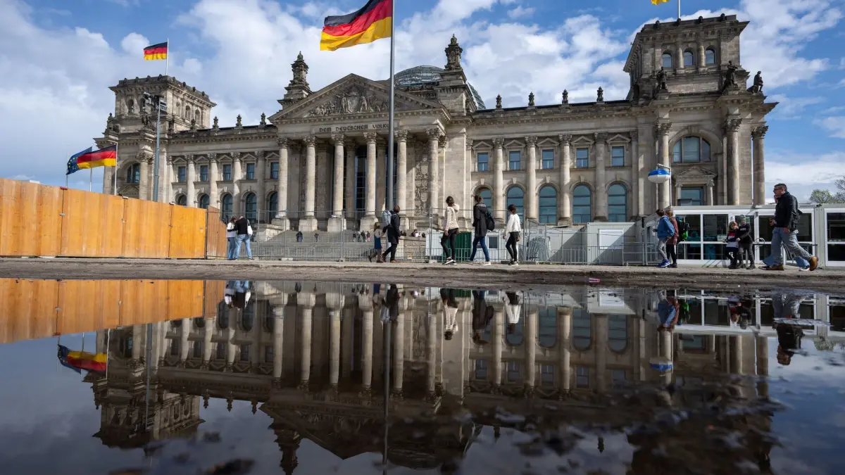Reichstag: ARCHIV - 05.04.2024, Berlin: Passanten gehen beim sonnigen Wetter an dem Reichstagsgebäude vorbei. (zu dpa: «Sondersitzungen zu Entscheidungen vor dem Atomausstieg») Foto: Monika Skolimowska/dpa +++ dpa-Bildfunk +++