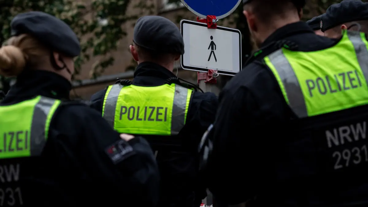 Razzia in Türsteherszene in Nordrhein–Westfalen: 04.05.2024, Nordrhein-Westfalen, Düsseldorf: Polizisten stehen an einer Absperrung in der Altstadt von Düsseldorf. Die Ermittler wollen mehr über die Geschäfte einflussreicher Familienclans im Sicherheits- und Bewachungsgewerbe herausfinden. Nordrhein-Westfalens Innenminister Reul (CDU) verfolgt die Razzia vor Ort. Foto: Fabian Strauch/dpa +++ dpa-Bildfunk +++