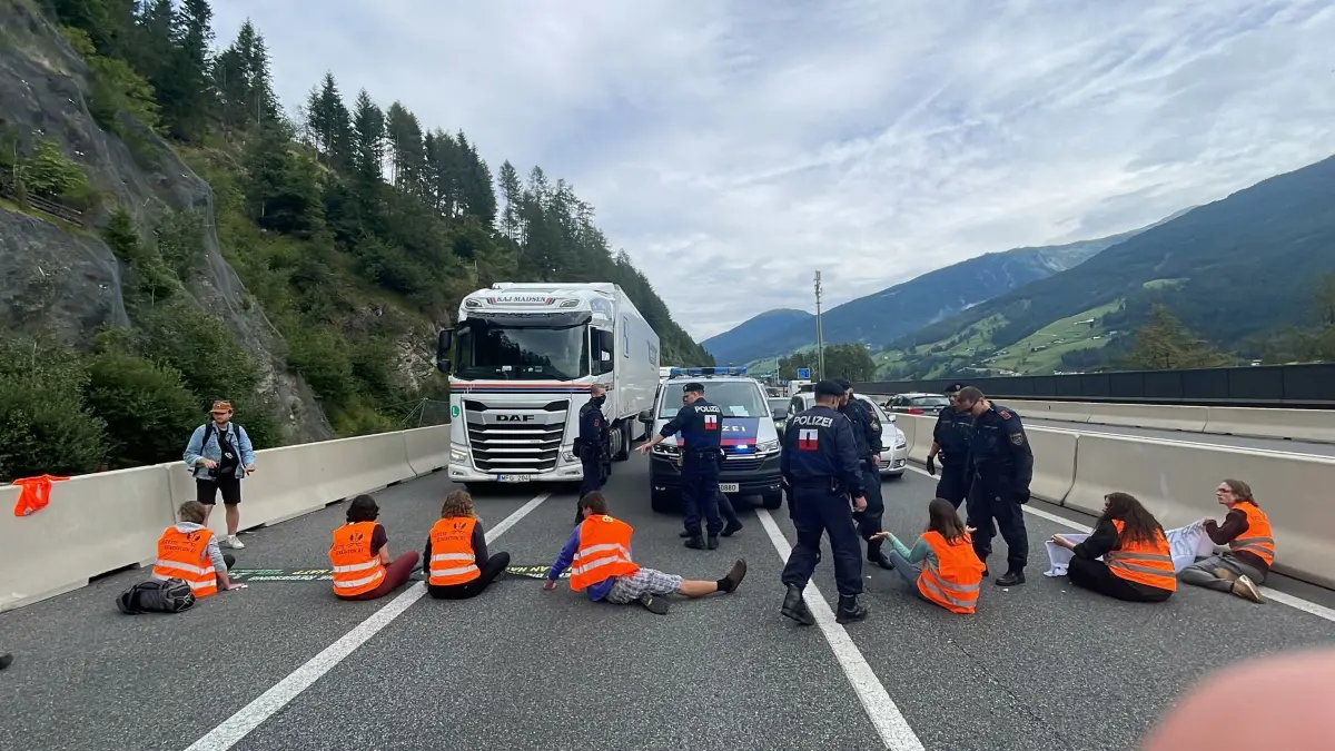Klimaaktivisten blockierten Brennerautobahn in Österreich: HANDOUT - 29.07.2023, Österreich, Matrei am Brenner: Klimaaktivisten der Gruppierung «Letzte Generation» blockieren die Brennerautobahn (A13) in Tirol nahe Matrei am Brenner. Nach Angaben der Tiroler Polizei klebten sich sieben der insgesamt neun Aktivistinnen und Aktivisten auf der Fahrbahn der A13 in Richtung Italien fest. Die Route über den Brennerpass ist eine wichtige Verkehrsachse zwischen Deutschland und Italien. «Während Südeuropa brennt und weltweit Hitzerekorde fallen, fordern die Bürger:innen endlich Taten beim Überlebensschutz», schrieb die Letzte Generation auf Twitter und forderte die Umsetzung der Empfehlungen des österreichischen Klimarates. (zu dpa: «Brenner-Zulauf: DB will Lähmung überwinden - Plan auf der Zielgeraden») Foto: ---/LETZTE GENERATION ÖSTERREICH/APA/dpa +++ dpa-Bildfunk +++