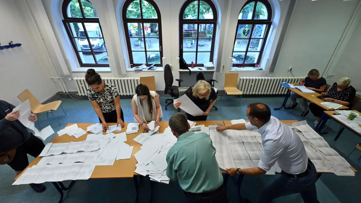 Europawahl — Thüringen: 09.06.2024, Thüringen, Erfurt: Wahlhelfer sortieren die Stimmzettel der Stichwahl und der Europawahl in einem Wahllokal in der Landeshauptstadt Thüringen. Die Europawahl begann am 6. Juni und in Deutschland wurde am 9. Juni gewählt. Neben der Europawahl fand in einigen Kommunen Thüringens die Stichwahl der Kommunalwahlen statt. Foto: Martin Schutt/dpa +++ dpa-Bildfunk +++