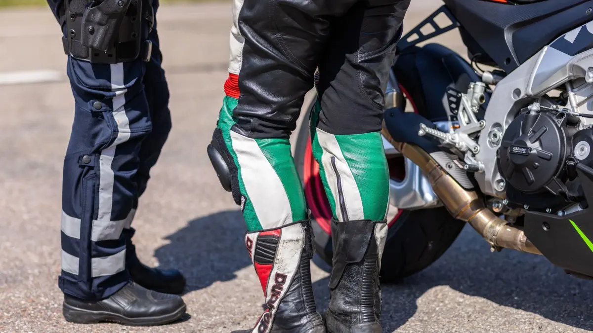 PRODUKTION - 27.06.2024, Baden-Württemberg, Forbach: Ein Polizist steht neben einer Motorradfahrerin und ihrem Motorrad. Der Verkehrsdienst des Polizeipräsidiums Offenburg führt auf Motorrad-Schwerpunktstrecken Kontrollen durch, am 27.06.2024 zum ersten Mal unter Beteiligung der französischen Gendarmerie. (zu dpa: «Polizei kontrolliert bei Motorrädern auch Lärmpegel») Foto: Philipp von Ditfurth/dpa +++ dpa-Bildfunk +++