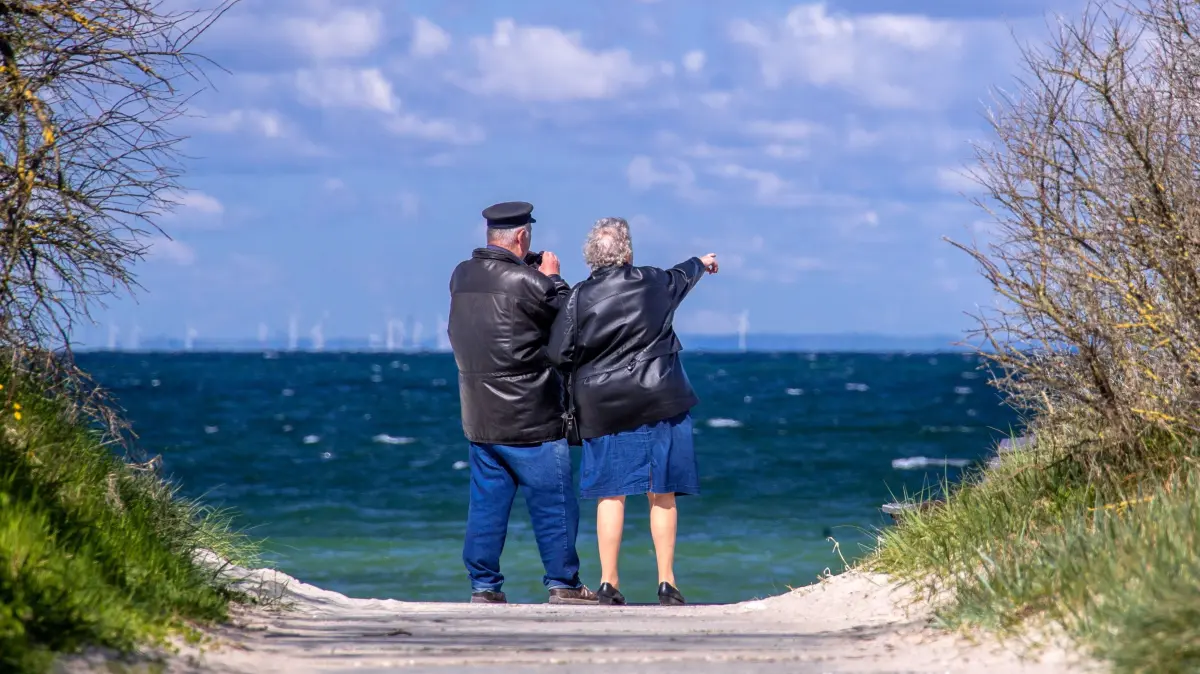 Ein Rentnerpaar steht am ansonsten menschenleeren Strand und schaut aufs Meer. Eine Koppelung des Rentenalters an die Lebenserwartung könnte nach Einschätzung der Bundesbank das System der gesetzlichen Rente langfristig stabilisieren. (Zu dpa "Bundesbank: Rentenalter an Lebenserwartung koppeln hätte Vorteile") +++ dpa-Bildfunk +++