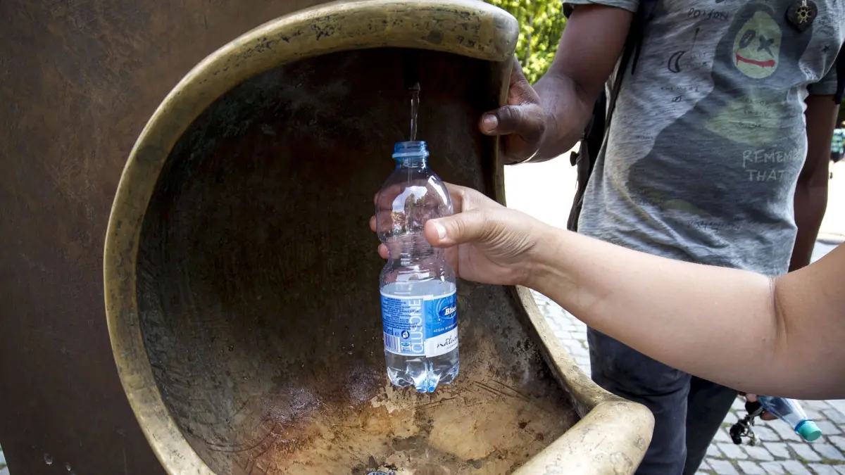 Die Stadt schwitzt unter der Hitzewelle die Stuttgart erreicht hat .Hitzefeature. Wasser auffüllen am Trinkbrunnen. Leif-Hendrik Piechowski , Friedrichstrasse 15 , 70174 Stuttgart , Tel.: 01702734084 , www.lichtgut-stuttgart.de , leif@lichtgut-stuttgart.de
