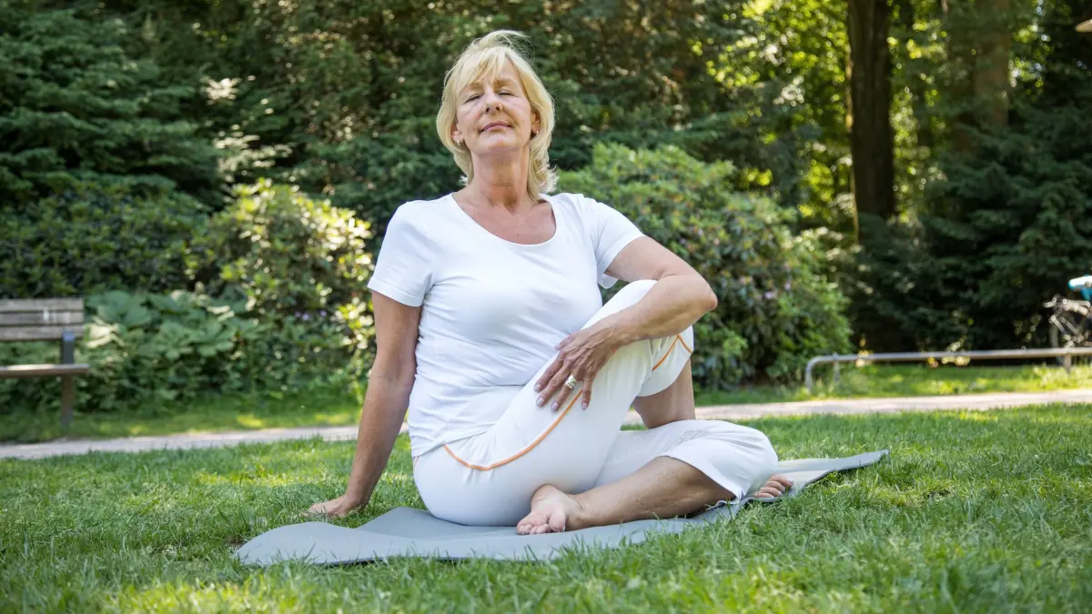 Eine Best Agerin macht Yoga: ILLUSTRATION - In Bewegung bleiben: Bei einer Arthrose ist wichtig, dass die Gelenke nicht einsteifen. Dabei helfen Sportarten wie Yoga und Pilates. (zu dpa: «Diagnose Arthrose? Das können Sie nun selbst tun») Foto: Christin Klose/dpa-tmn - Honorarfrei nur für Bezieher des dpa-Themendienstes +++ dpa-Themendienst +++
