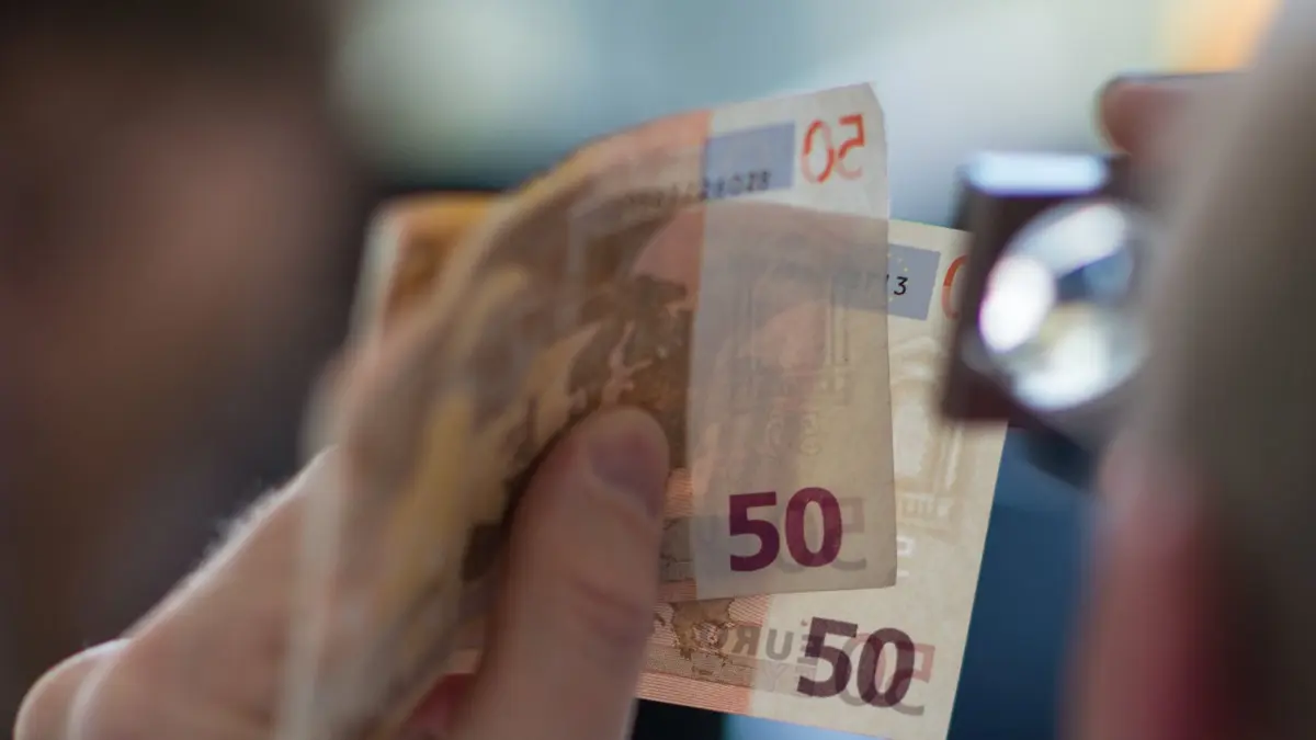 ARCHIV - ILLUSTRATION - Ein Mitarbeiter des Nationalen Analysezentrums an der Deutschen Bundesbank prüft am 30.03.2017 in Mainz (Rheinland-Pfalz) mit der Lupe zwei 50 Euro-Banknoten. (zu dpa «Weniger Falschgeld in Sachsen-Anhalt» vom 01.02.2018) Foto: Andreas Arnold/dpa +++ dpa-Bildfunk +++