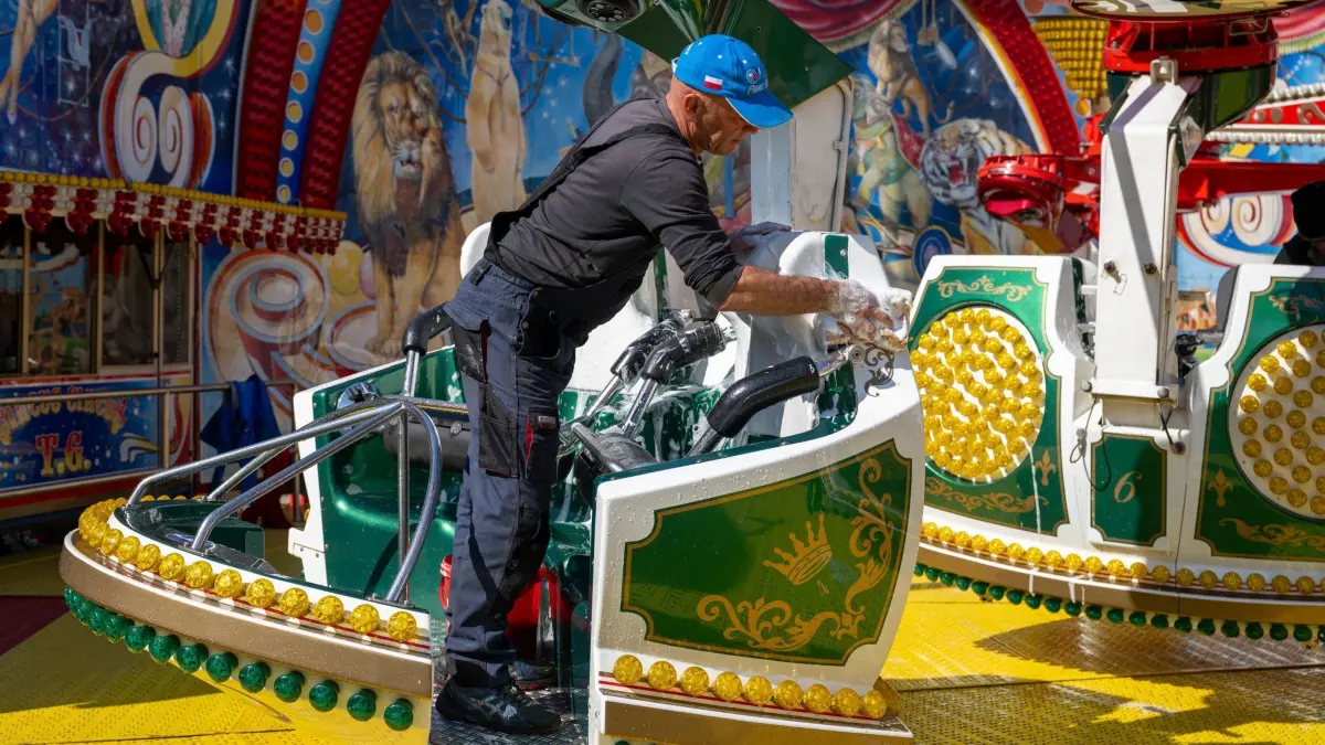 Presserundgang auf dem Oktoberfest: 19.09.2024, Bayern, München: Ein Arbeiter reinigt während eines Presserundgangs auf dem Oktoberfest die Gondeln eines Fahrgeschäfts. Das diesjährige Oktoberfest findet von 21.09. bis 06.10 auf der Theresienwiese in München statt. Foto: Lennart Preiss/dpa +++ dpa-Bildfunk +++