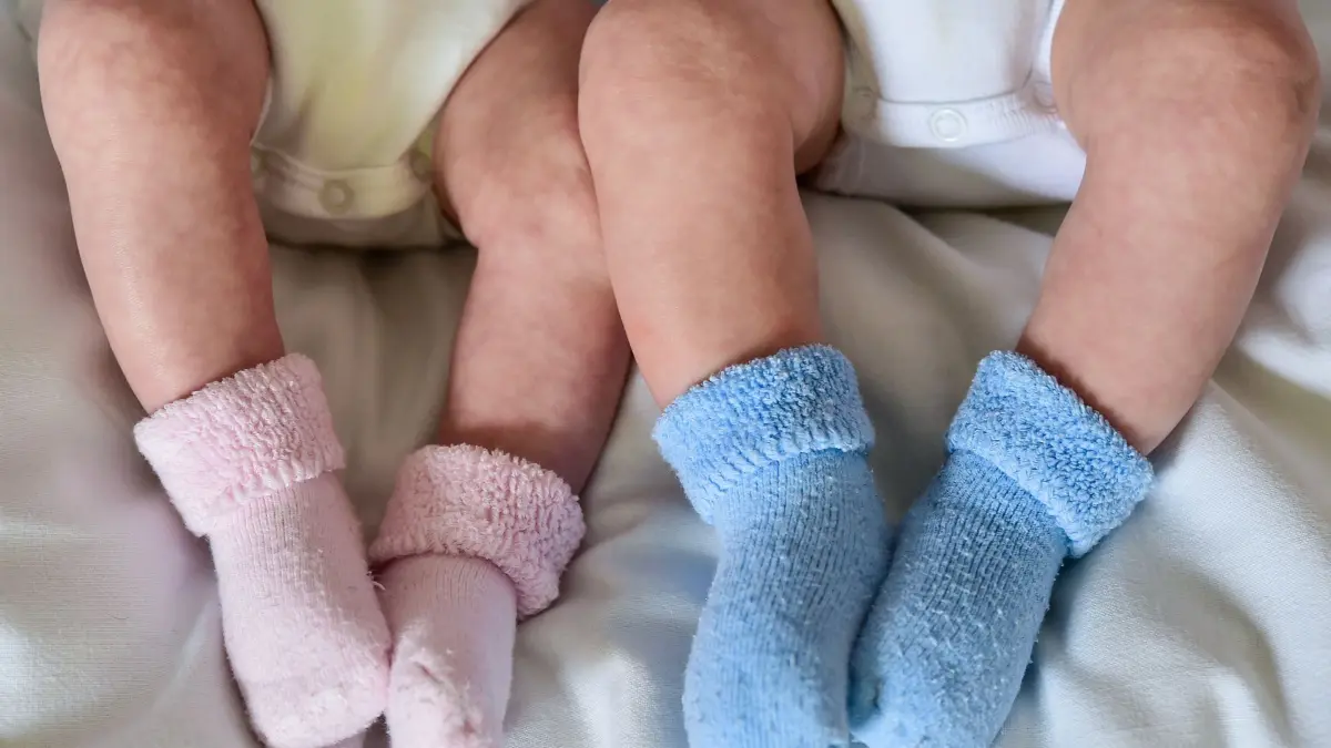 Geschwister - Mädchen und Junge: ARCHIV - 14.04.2015, Brandenburg, Frankfurt (Oder): ILLUSTRATION - Rosa und blaue Söckchen für ein Mädchen und einen Jungen und die nackten Babybeine von Zwillingen, aufgenommen in einem Babybettchen. In Deutschland kommen immer mehr Kinder in einer Mehrlingsgeburt zur Welt. Seit den 1980er Jahren steige der Anteil von Zwillingen, Drillingen oder Vierlingen an, teilte das Statistische Bundesamt in Wiesbaden mit. (zu dpa: «Drei Zwillingspaare in Halle an einem Tag geboren») Foto: Patrick Pleul/dpa-Zentralbild/dpa +++ dpa-Bildfunk +++