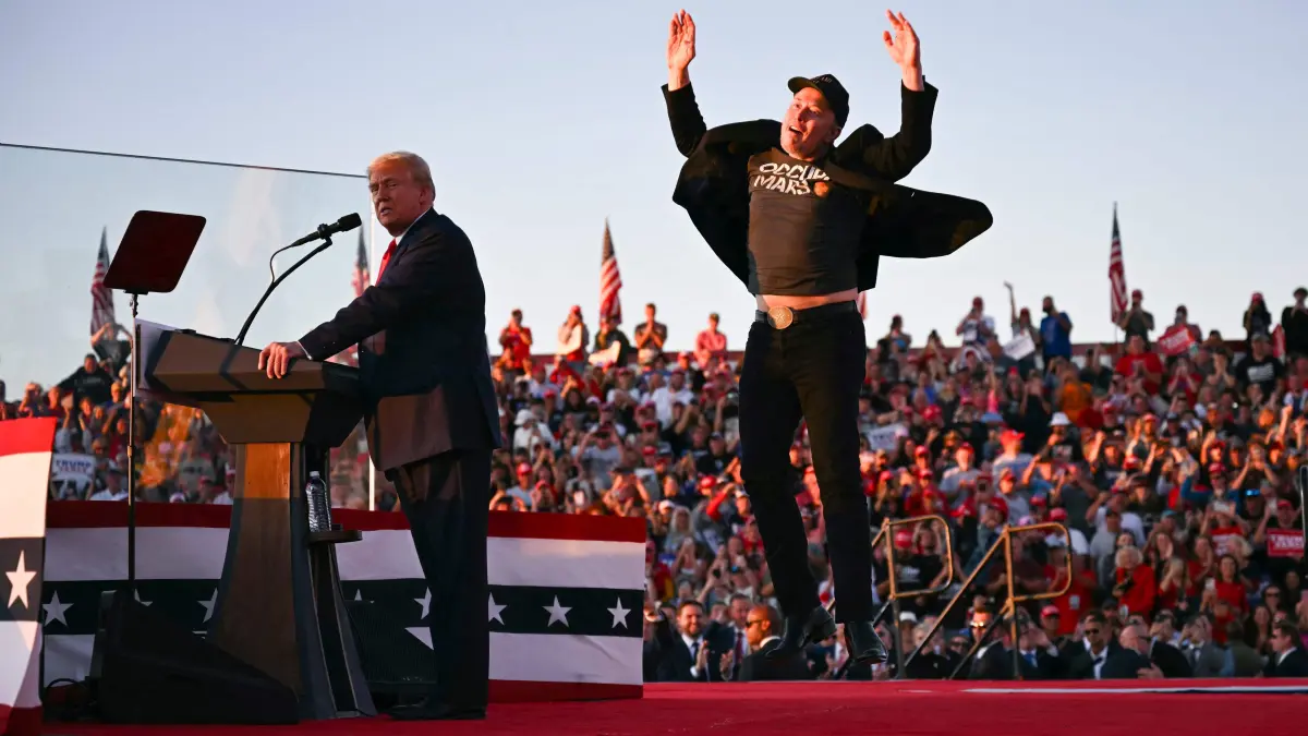(FILES) Tesla CEO Elon Musk (R) jumps on stage as he joins former US President and Republican presidential candidate Donald Trump during a campaign rally at site of his first assassination attempt in Butler, Pennsylvania on October 5, 2024. Billionaire Elon Musk was expected in court in Philadelphia on October 31, 2024, after a judge ordered him to attend a hearing in a lawsuit seeking to halt his $1 million giveaways to registered US voters in swing states. (Photo by Jim WATSON / AFP)