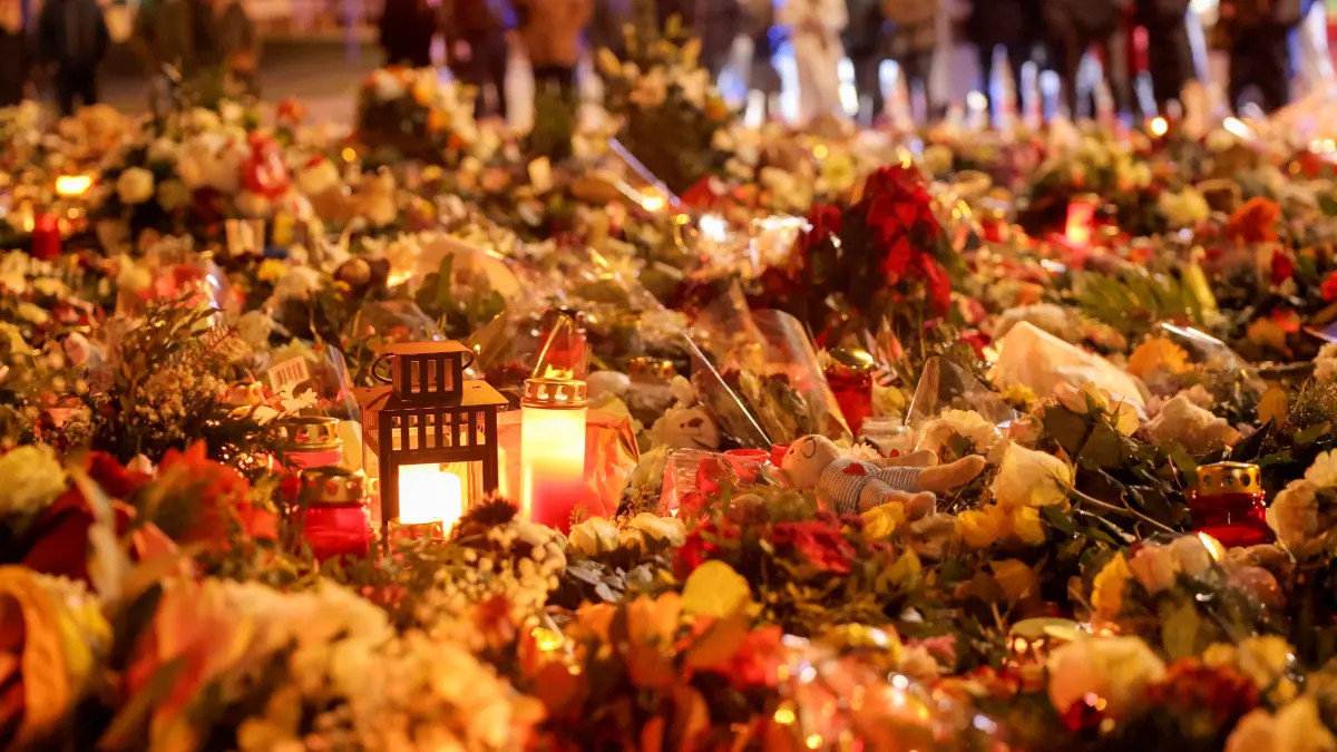 Trauer nach Anschlag auf Magdeburger Weihnachtsmarkt : Am Abend - 24 Stunden nach der Amokfahrt auf dem Magdeburger Weihnachtsmarkt - herrscht an der Johanniskirche noch immer tiefe Trauer. Ein riesiges Meer aus Blumen, Kerzen und Plüschtieren leuchten am Sonntagabend an der Johanniskirche. Magdeburg steht noch immer unter Schock. Auch der 9-jährige Andre starb in Magdeburg. Ein Jugendfeuerwehrhelm erinnert an den 9-Jährigen aus Warle, der auch in der Jugendfeuerwehr war. Am Abend humpelten auch Opfer mit Seelsorgern zur Johanniskirche. Zusammen mit Seelsorgern wollen sie die Ereignisse verarbeiten (on tape). Die Absperrungen am Weihnachtsmarkt wurden weggeräumt. Die Menschen konnten über den leuchteten, aber geschlossenen Weihnachtsmarkt laufen.
