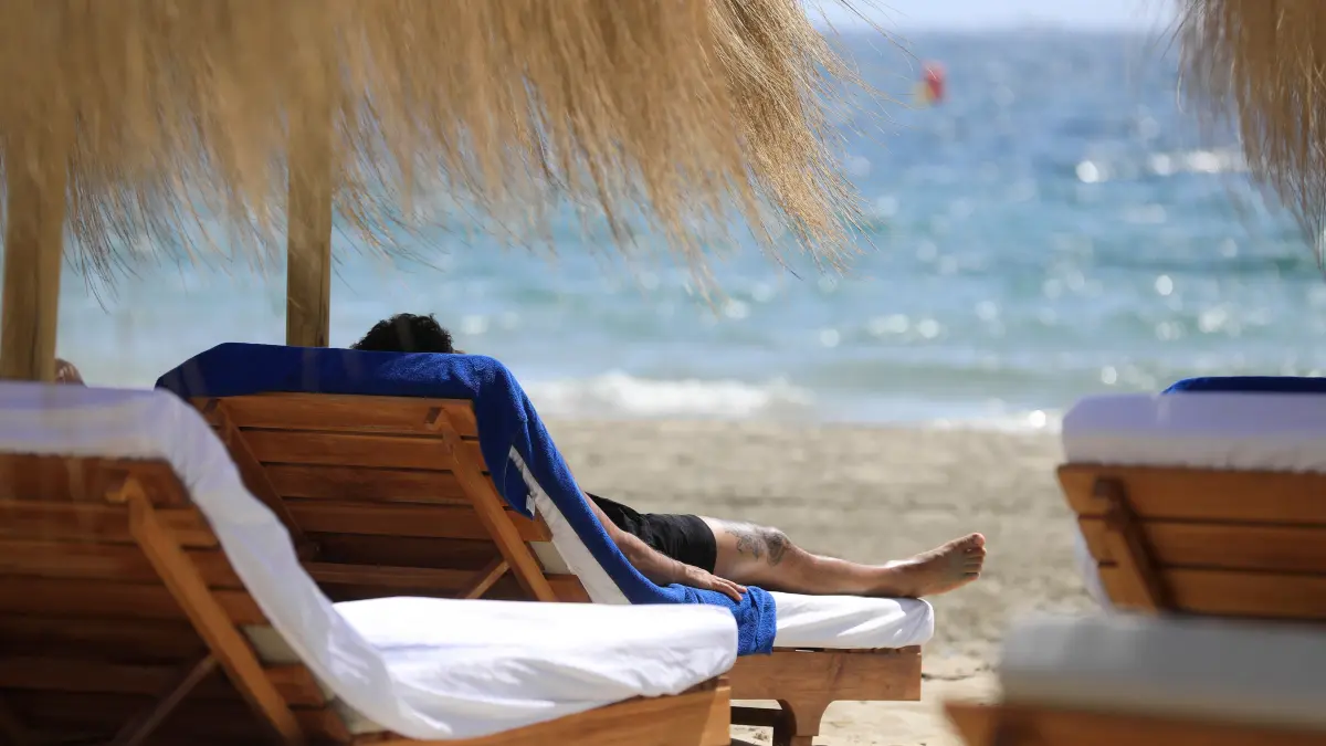Ein Mann sonnt sich am Strand Platja d'en Bossa. +++ dpa-Bildfunk +++