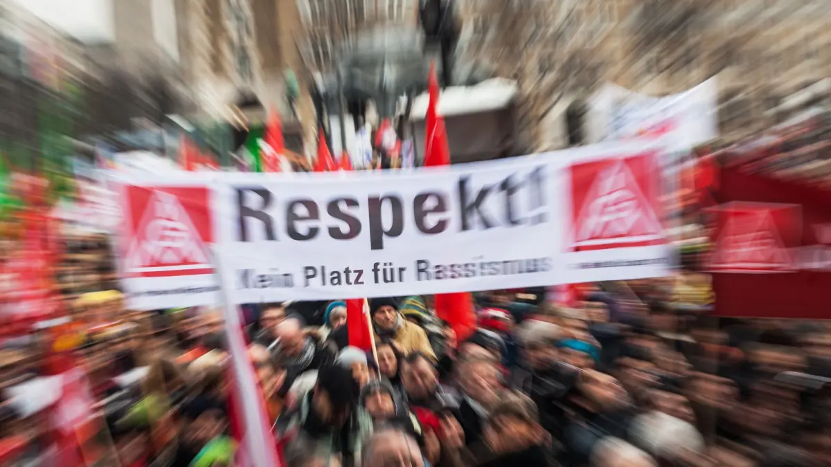 Ein Banner mit der Aufschrift "Respekt! Kein Platz für Rassismus" wird am 16.01.2016 auf dem Schlossplatz in Stuttgart (Baden-Württemberg) bei einer Kundgebung gegen Rassismus und Gewalt von Demonstranten in die Höhe gehalten. Zu der Kundgebung hatte ein Bündnis von mehr als 20 Organisationen aus Politik, Gewerkschaften, Arbeitgebern, Sportverbänden und der Türkischen Gemeinde aufgerufen. (Aufnahme mit Zoomeffekt fotografiert) Foto: Christoph Schmidt/dpa +++(c) dpa - Bildfunk+++
