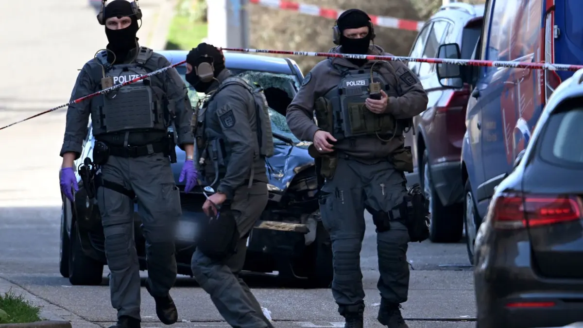 Polizeieinsatz in Mannheim: 03.03.2025, Baden-Württemberg, Mannheim: Beamte des Entschärfungsdienstes der Polizei sind an einem beschädigten Fahrzeug an einer Zufahrt zur Rheinbrücke im Einsatz. Nach einem Vorfall mit einem Auto in der Mannheimer Innenstadt mit mindestens einem Toten und mehreren Verletzten ist der mutmaßliche Fahrer nach Polizeiangaben festgenommen worden. Nach Polizeiangaben war ein Fahrzeug in eine Menschenmenge gefahren. Foto: Boris Roessler/dpa +++ dpa-Bildfunk +++