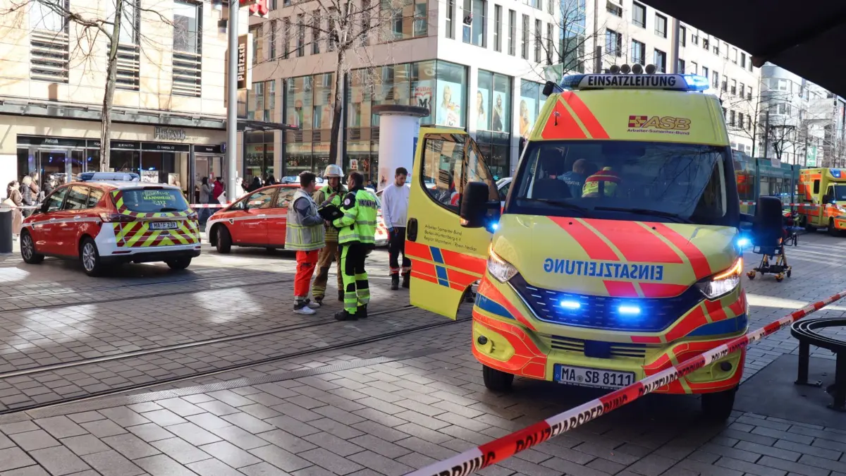 Polizeieinsatz in Mannheim: 03.03.2025, Baden-Württemberg, Mannheim: Rettungskräfte stehen bei einem Großeinsatz der Polizei in der Innenstadt. Einem dpa-Reporter zufolge waren am Ort des Geschehens Trümmer zu sehen, mindestens eine Person lag demnach abgedeckt unter einer Plane. Augenzeugen zufolge war ein Fahrzeug in eine Menschenmenge gefahren. Foto: René Priebe/dpa +++ dpa-Bildfunk +++