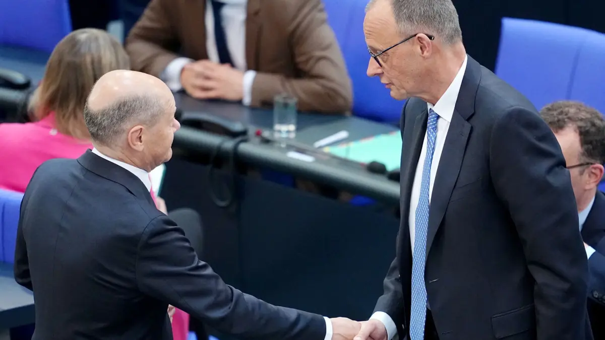 Bundestag - Kanzlerwahl: 06.05.2025, Berlin: Der geschäftsführende Bundeskanzler Olaf Scholz (SPD, l) wünscht dem designierten Bundeskanzler Friedrich Merz (CDU) mit Bundestag beim zweiten Durchgang der Kanzlerwahl per Handschlag Glück. Nach dem Scheitern von CDU-Chef Merz im ersten Anlauf bei der Wahl zum Bundeskanzler soll es noch am Dienstag einen zweiten Wahlgang im Bundestag geben. Foto: Kay Nietfeld/dpa +++ dpa-Bildfunk +++