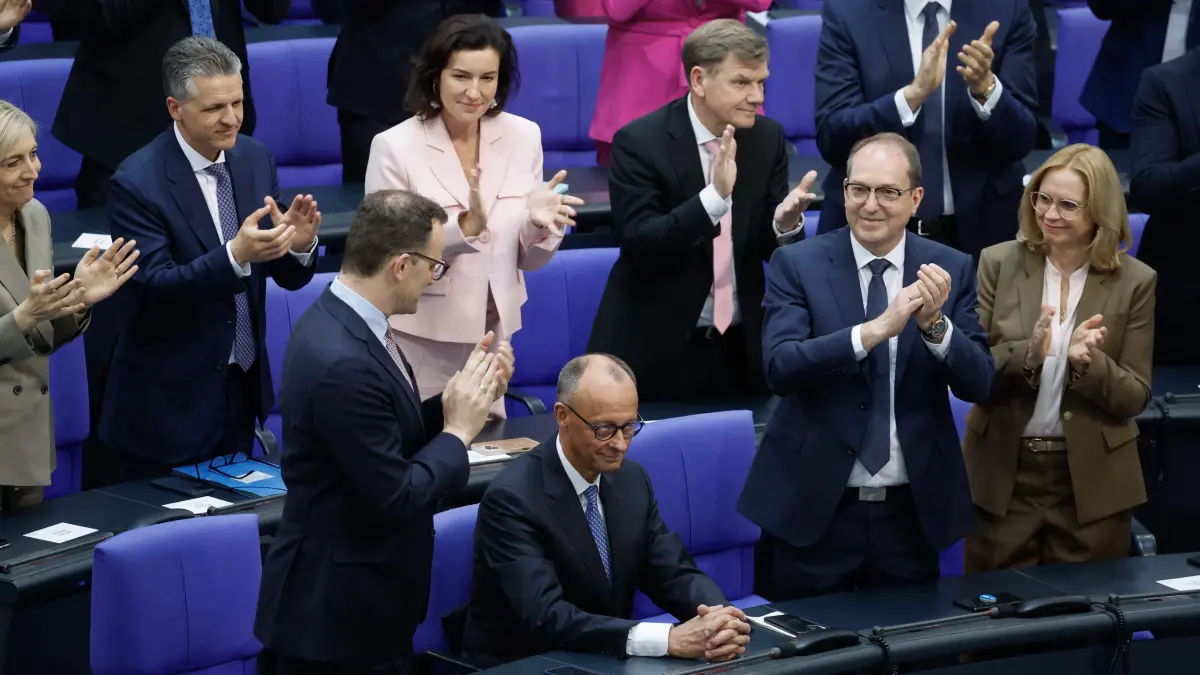 Designated German Chancellor Friedrich Merz (2ndL, front row) is applauded by party members among them Parliamentary group leader of Germany's Christian Democratic Union (CDU) Jens Spahn (L) and designated Interior Minister and member of the Bavarian conservative Christian Social Union (CSU) party Alexander Dobrindt (2ndR) a second round of voting during a session at the Bundestag (lower house of parliament) where the parliament is to elect the Germany's next Chancellor, in Berlin on May 6, 2025. Germany's conservative leader Friedrich Merz face a second vote in parliament on May 6, 2025 in his bid to become chancellor after he lost the first round in a stunning early setback. Even if he ends up becoming post-war Germany's 10th chancellor, the initial shock defeat dealt a heavy blow to Merz who has vowed to restore stability in Berlin after half a year of political turmoil. (Photo by Odd ANDERSEN / AFP)
