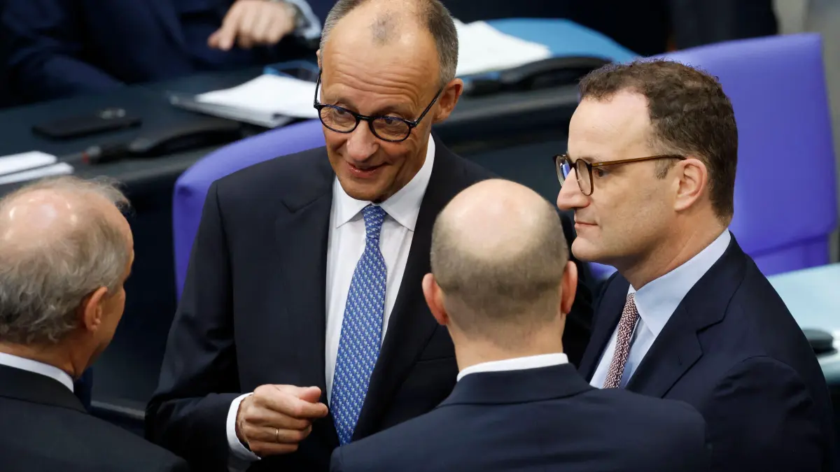 The leader of Germany's conservative Christian Democratic Union (CDU) party and designated chancellor Friedrich Merz (2ndL) speaks with CDU parliamentary group leader Jens Spahn (R) and others during a session at the Bundestag (lower house of parliament) in Berlin on May 6, 2025 before a vote to elect the country's next chancellor. Germany's far-right AfD on May 6 called for a fresh general election after a shock vote in parliament saw conservative leader Merz miss a majority to become chancellor. Merz had expected to win a majority of at least 316 of the 630 votes in the lower house of parliament. But he won the backing of only 310 MPs, with 307 voting against him. (Photo by Odd ANDERSEN / AFP)