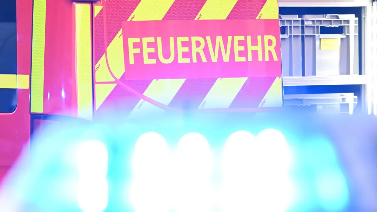 ARCHIV - 02.05.2025, Baden-Württemberg, Stuttgart: Ein Fahrzeug der Feuerwehr steht bei einem Einsatz auf einer Straße, während im Vordergrund das Blaulicht eines Polizeifahrzeugs zu sehen ist. (zu dpa: «Croissants lösen in der Nacht Feuerwehreinsatz aus») Foto: Bernd Weißbrod/dpa +++ dpa-Bildfunk +++