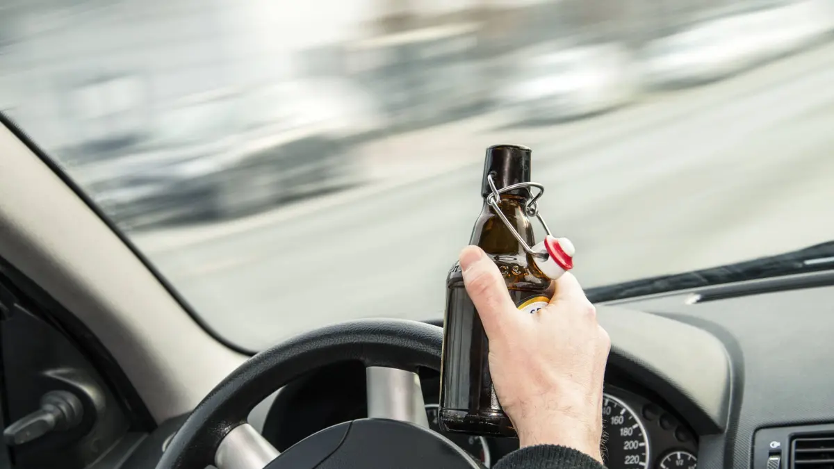 Alkohol am Steuer Geöffnete Flasche Bier und Hände am Lenkrad eines Autos Copyright: xZoonar.com/ironjohnx 11803067