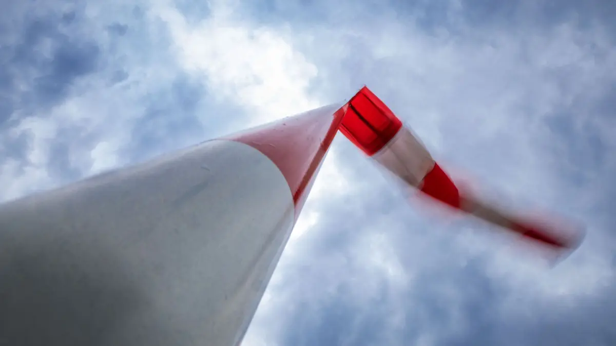27.06.2025, Mecklenburg-Vorpommern, Rostock: Ein Windsack flattert unter dunklen Regenwolken bei Sturm an einem Mast. Mit kräftigem Wind, viel Regen und Temperaturen um die 15 Grad zeigt sich das Wetter in Norddeutschland von seiner rauen Seite. Foto: Jens Büttner/dpa +++ dpa-Bildfunk +++