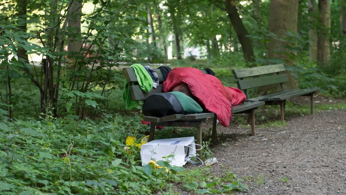 Obdachlosigkeit: ARCHIV - 21.06.2017, Berlin: Ein Obdachloser liegt am frühen Morgen auf einer Bank (zu dpa: «Regierung bewertet Modellprojekte für Wohnungslose positiv») Foto: Paul Zinken/dpa +++ dpa-Bildfunk +++