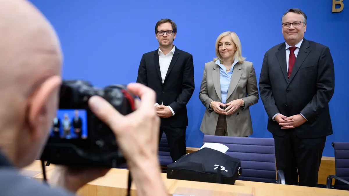 Gesundheitsministerin Warken beruft Kommission: 12.09.2025, Berlin: Nina Warken (M, CDU), Bundesministerin für Gesundheit, stellt zusammen mit Gregor Thüsing (r), Professor für Arbeitsrecht und Direktor des Instituts für Arbeitsrecht und das Recht der sozialen Sicherheit an der Rheinische Friedrich-Wilhelms-Universität Bonn, und Michael Laxy (l), Professur für Public Health und Prävention an der Technischen Universität München, in der Bundespressekonferenz die Kommission zur Stabilisierung der gesetzlichen Krankenversicherung (GKV) vor. Die gesetzliche Krankenversicherung steht finanziell massiv unter Druck. Die Ausgaben wachsen weiterhin deutlich stärker als die Einnahmen. Foto: Bernd von Jutrczenka/dpa +++ dpa-Bildfunk +++