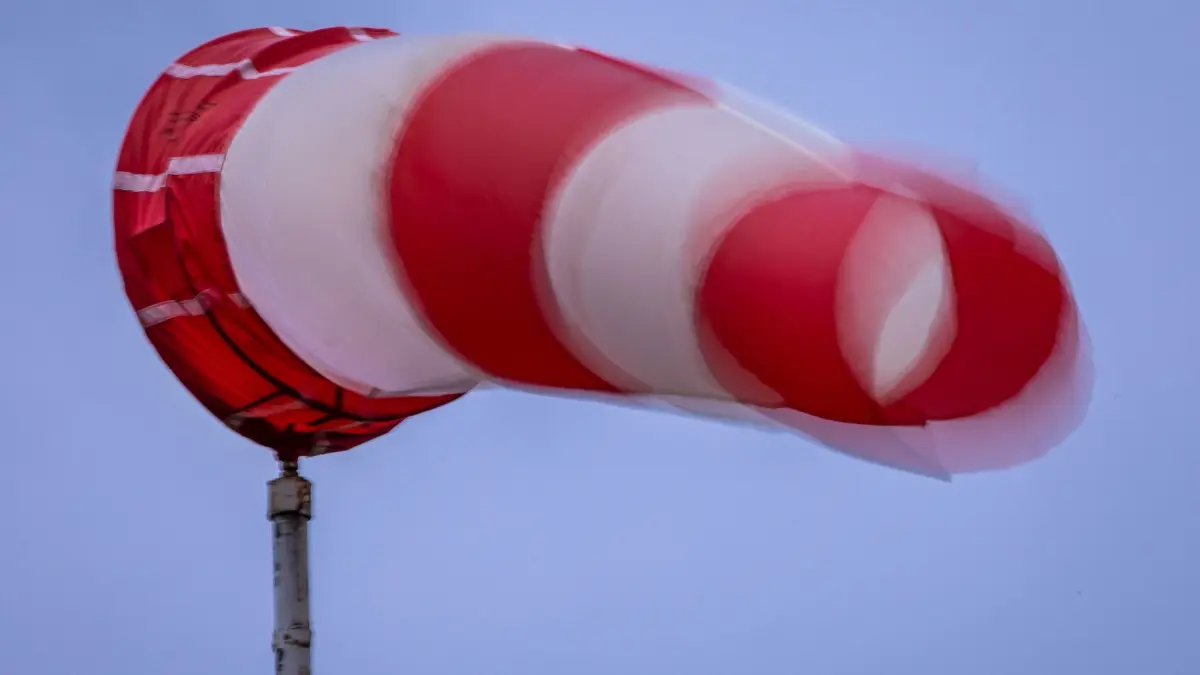 Windsack weht bei Regen und kräftigem Wind am Mast: 16.09.2025, Mecklenburg-Vorpommern, Wismar: Tempo drosseln, Abstand halten und beide Hände am Lenkrad: Bei Sturm ist eine vorausschauende, konzentrierte Fahrweise noch wichtiger. (zu dpa: «Sturm über dem Norden erwartet») Foto: Jens Büttner/dpa/dpa-tmn +++ dpa-Bildfunk +++
