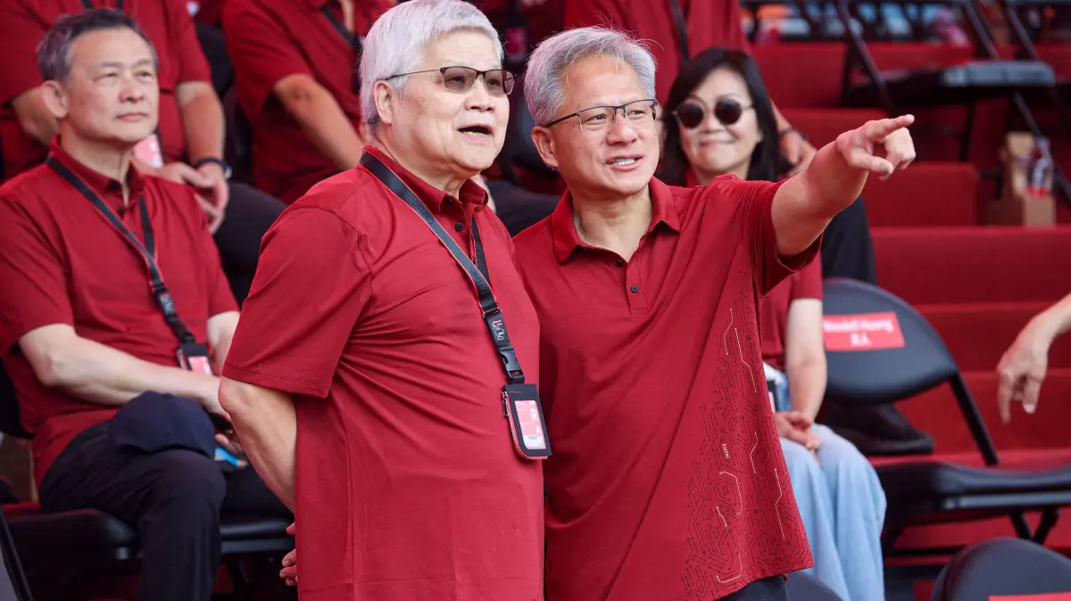 This picture taken and released by Taiwan’s Central News Agency (CNA) on November 8, 2025 shows Che-Chia Wei (L), chief executive officer of Taiwan Semiconductor Manufacturing Co. (TSMC), and Jensen Huang (R), chief executive officer of Nvidia Corp., attending the TSMC sports day event in Hsinchu. (Photo by Handout / Taiwan's Central News Agency (CNA) / AFP) / Taiwan OUT - China OUT - Hong Kong Special Administrative Region OUT - Macau OUT / RESTRICTED TO EDITORIAL USE - MANDATORY CREDIT "AFP PHOTO / CNA Photo" - NO MARKETING - NO ADVERTISING CAMPAIGNS - DISTRIBUTED AS A SERVICE TO CLIENTS