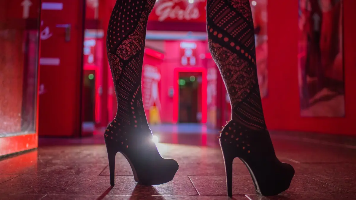 Prostitution: ARCHIV - 12.07.2017, NA, Frankfurt/Main: Eine Frau steht im Eingangsbereich einer Animierbar und eines Bordells. (zu dpa: «Prozess in Bielefeld: Schleuserbande vor Gericht») Foto: Andreas Arnold/dpa +++ dpa-Bildfunk +++
