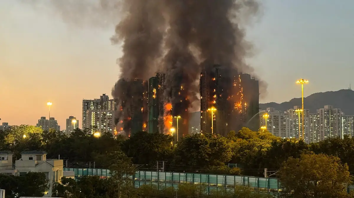 Thick smoke and flames rise as a major fire engulfs several apartment blocks at Wang Fuk Court in Hong Kong's Tai Po district on November 26, 2025. Four people died after multiple blocks in a Hong Kong residential estate went up in flames on November 26, with local media earlier reporting that some residents were trapped. (Photo by Yan ZHAO / AFP)