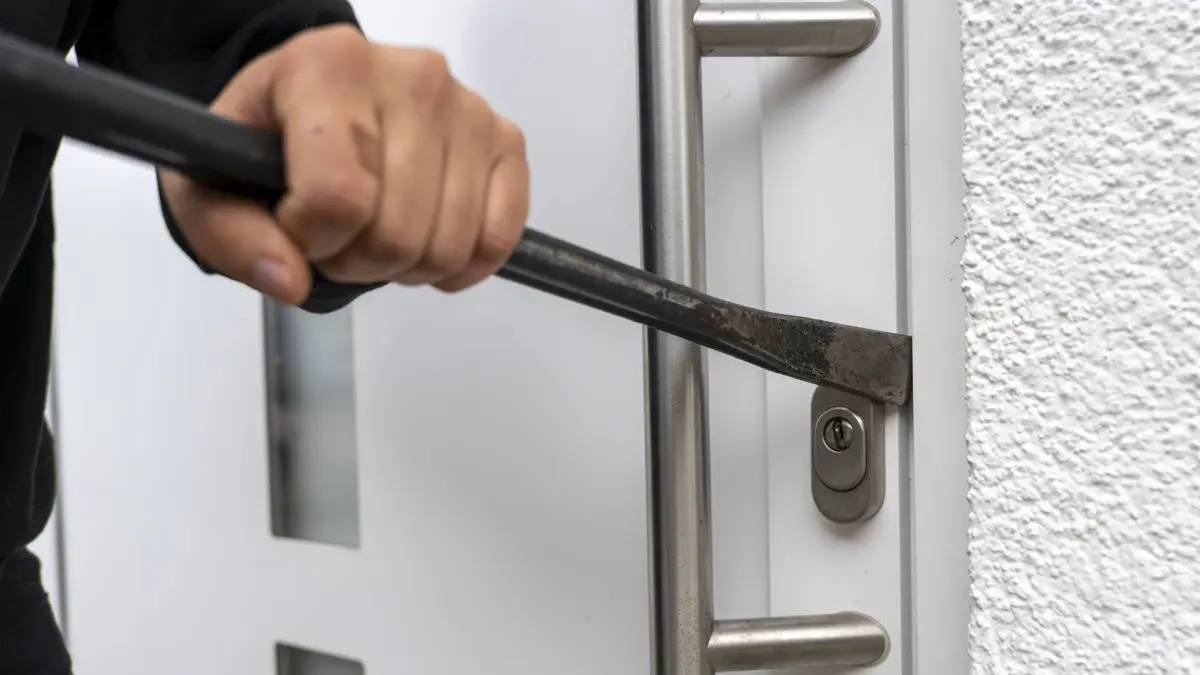 21.11.2022, Thema Einbruchdiebstahl in Wohnhäuser, Symbolbild, Einbrecher versucht mit Brecheisen die Haustüre aufzubrechen um in eine Wohnung zu kommen. Model Release vorhanden 21.11.2022, Diebstahl und Einbruch 21.11.2022, Diebstahl und Einbruch *** 21 11 2022, residential burglary theme, symbol image, burglar tries to pry open front door with crowbar to get into an apartment Model release available 21 11 2022, theft and burglary 21 11 2022, theft and burglary