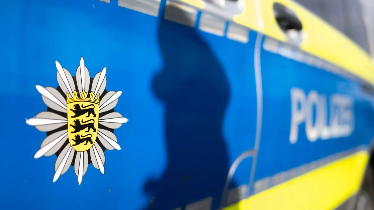 Polizei Baden-Württemberg: ILLUSTRATION - 20.11.2025, Baden-Württemberg, Stuttgart: Der Schatten einer Polizistin der Polizei Baden-Württemberg zeichnet sich an der Tür eines Polizeifahrzeugs ab. (gestellte Szene) (zu dpa: «Junger Mann mietet Auto mit gestohlenem Führerschein: Unfall») Foto: Marijan Murat/dpa +++ dpa-Bildfunk +++