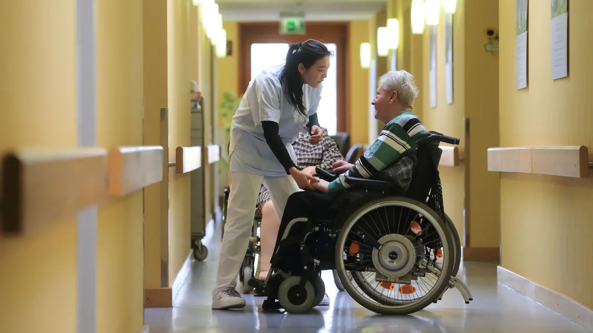 Pflegepersonal in Magdeburger Altenheim: ARCHIV - 09.03.2015, Sachsen-Anhalt, Magdeburg: Eine Pflegeassistentin spricht mit einer Bewohnerin in einem Seniorenheim in Magdeburg. (zu dpa: «Pflegeheime in Sachsen-Anhalt werden teurer») Foto: Jens Wolf/dpa-Zentralbild/dpa +++ dpa-Bildfunk +++