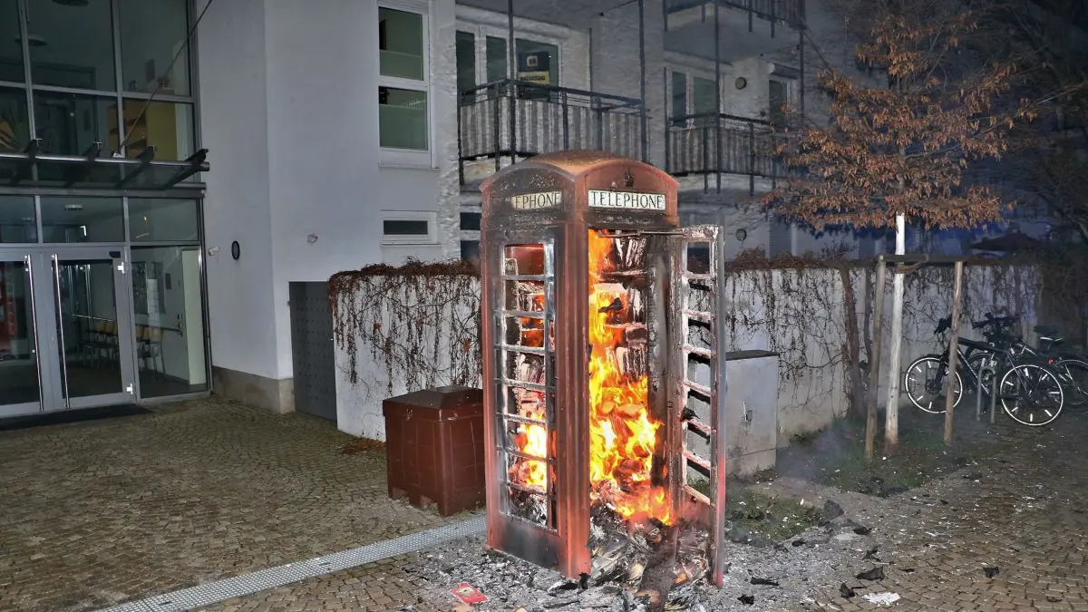 24.01.2026: Die Freiwillige Feuerwehr Gerlingen wurde in den frühen Morgenstunden des 24.1.2026 zum Europaplatz in der Gerlinger Stadtmitte alarmiert. Beim Eintreffen gegen 3:50 Uhr stand eine englische Telefonzelle, genutzt als "Büchertausch-Zelle", lichterloh in Flammen. Die Besatzung eines zuerst eingetroffenen Streifenwagens hatte bereits erste Löschversuche unternommen, auf Grund der hohen Brandlast der vielen Bücher konnte der Pulverlöscher allerdings nichts ausrichten. Die Gerlinger Feuerwehr löschte die "Bücher-Zelle" mit einem Löschrohr unter Atemschutz und zog die zerstörten Bücher mit einem Dunghaken auseinander. Als Brandursache kann mit hoher Wahrscheinlichkeit von Brandstiftung ausgegangen werden, durch sinnlosen Vandalismus wurde eine beliebte und gern genutzte Gerlinger Einrichtung zerstört. Die original englische Telefonzelle wurde 1988 durch die englische Partnerstadt Seaham als Geschenk übergeben und diente zunächst in der Nähe des Rathausplatzes als "echte" Telefonzelle. 2014 zog sie dann auf den Europaplatz um und wurde dort durch den damaligen Bürgermeister Brenner und den Bürgermeister der Partnerstadt, Bruce Burn, als öffentliche Bücherbox eingeweiht. Seither konnten die Gerlinger Bürger dort unzählige Bücher einstellen, tauschen, mitnehmen - bis zum 24.1.2026.....
Foto: KS-Images.de/Andreas Rometsch