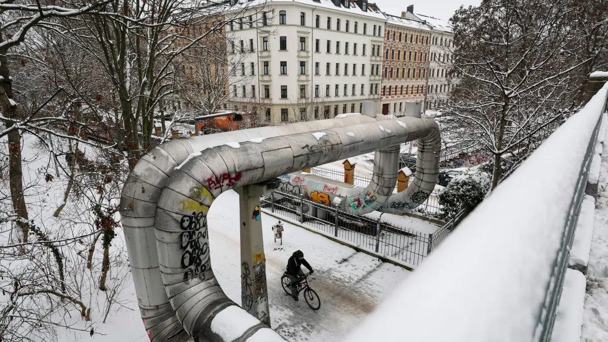 Winter in Leipzig - Fernwärme: 27.01.2026, Sachsen, Leipzig: Eine Fernwärmeleitung führt durch ein verschneites Gründerzeitviertel. Foto: Jan Woitas/dpa +++ dpa-Bildfunk +++