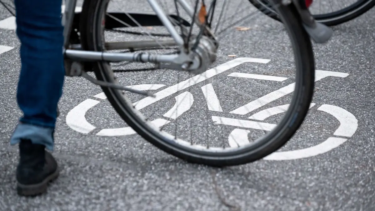 Fahrradfahrer (Symbolbild): ARCHIV - 31.10.2021, Hamburg: Ein Fahrrad-Symbol ist auf der Fahrbahn einer Straße hinter einem Fahrrad zu sehen. (zu dpa: «Radfahrer will Straße überqueren und stößt mit Auto zusammen») Foto: Jonas Walzberg/dpa +++ dpa-Bildfunk +++