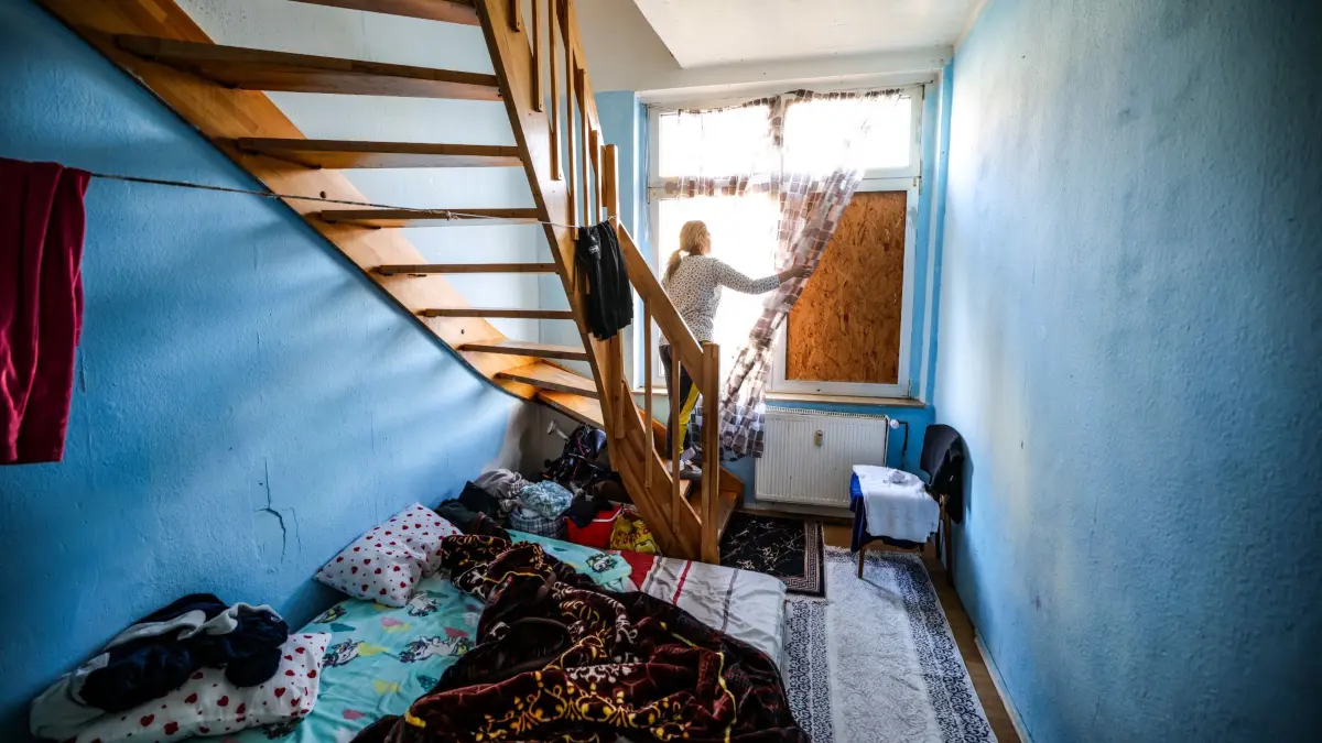 Wie NRW Ausbeutung mit Schrottimmobilien stoppen will: ARCHIV - 04.03.2026, Nordrhein-Westfalen, Dortmund: Eine Frau aus Bulgarien steht in einem Zimmer ihrer Wohnung in einer Dortmunder Schrottimmobilie. In Nordrhein-Westfalen soll künftig schärfer gegen Zweckentfremdung von Wohnraum, ausbeuterische Unterbringung Beschäftigter und Schrottimmobilien vorgegangen werden. (zu dpa: «Wie NRW Ausbeutung mit Schrottimmobilien stoppen will») Foto: Christoph Reichwein/dpa +++ dpa-Bildfunk +++