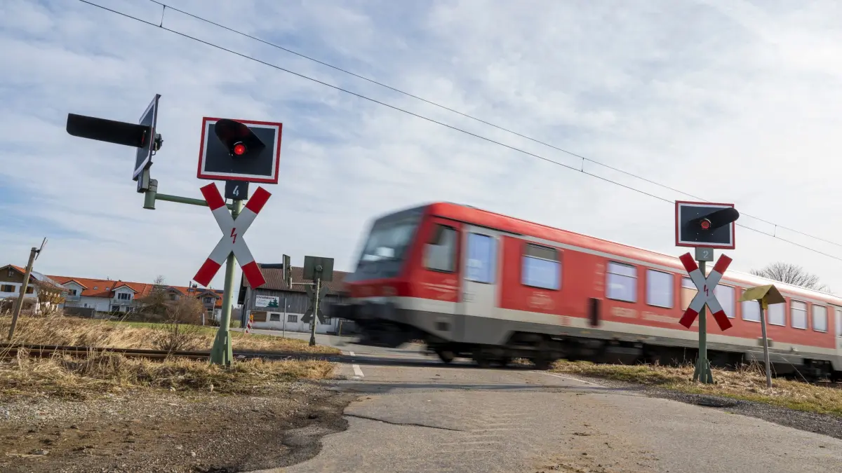 Unbeschrankter Bahnübergang: ARCHIV - 06.02.2024, Bayern, Grafing: Eine Regionalbahn fährt über einen unbeschrankten Bahnübergang. (zu dpa: «Bahnstrecke Mühldorf-München in Osterferien gesperrt») Foto: Peter Kneffel/dpa +++ dpa-Bildfunk +++
