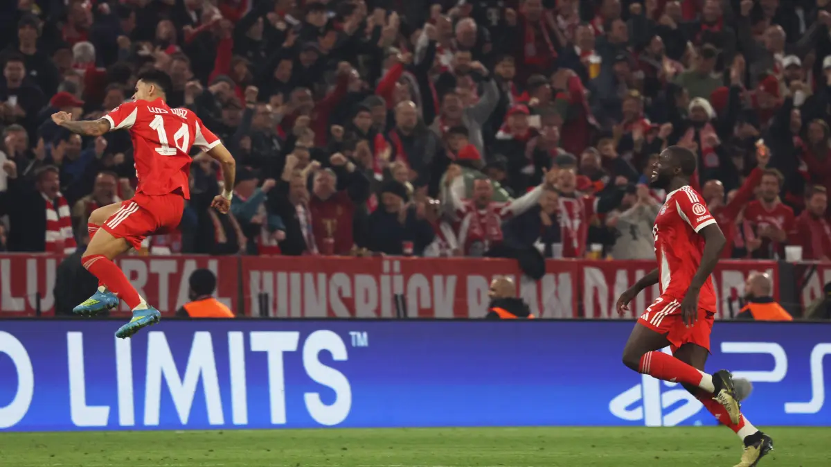 Bayern Munich's Colombian forward #14 Luis Diaz jumps to celebrate after (L) scoring the equalizing 3-3 goal during the UEFA Champions League quarter-final second leg football match between FC Bayern Munich and Real Madrid in Munich, southern Germany, on April 15, 2026. (Photo by Karl-Josef HILDENBRAND / AFP)