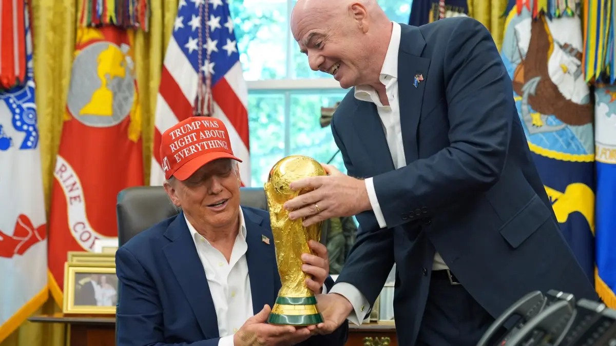 Donald Trump und Gianni Infantino: ARCHIV - 22.08.2025, USA, Washington: FIFA-Präsident Gianni Infantino (r) überreicht US-Präsident Donald Trump die FIFA World Cup Winners Trophy bei einer Ankündigung im Oval Office des Weißen Hauses. Ein Sonderbeauftragter des US-Präsidenten hat Italien als Iran-Ersatzteilnehmer vorgeschlagen. (zu dpa: «Italien statt Iran? US-Sonderbeauftragter mit WM-Vorschlag») Foto: Jacquelyn Martin/AP/dpa +++ dpa-Bildfunk +++