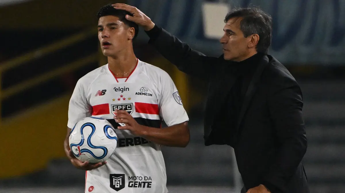 Millonarios' head coach Fabian Bustos (R) touches the head of Sao Paulo's defender #56 Nicolas Bosshardt during the Copa Sudamericana group stage football match between Colombia's Millonarios and Brazil's Sao Paulo at the Nemesio Camacho El Campin stadium in Bogota on April 28, 2026. (Photo by Luis ACOSTA / AFP)