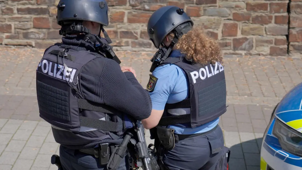 Geiselnahme in einer Bank in Rheinland-Pfalz: 08.05.2026, Rheinland-Pfalz, Sinzig: Polizisten stehen in der Nähe eines Einsatzortes. In einer Bankfiliale im rheinland-pfälzischen Sinzig ist es nach ersten Erkenntnissen der Polizei zu einer Geiselnahme gekommen. Die Einsatzkräfte sind mit einem Großaufgebot im Kreis Ahrweiler vor Ort. Foto: Sascha Ditscher/dpa +++ dpa-Bildfunk +++