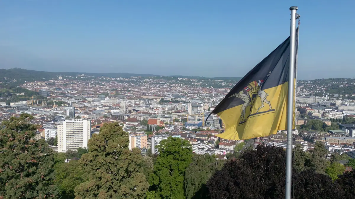 Villa Reitzenstein: 08.05.2026, Baden-Württemberg, Stuttgart: Blick auf die baden-württembergische Flagge auf dem Dach der Villa Reitzenstein, Sitz des Staatsministeriums Baden-Württemberg und Amtssitz des Ministerpräsidenten von Baden-Württemberg, im HIntergund ist ein Teil der Stuttgarter Innenstadt zu sehen (Luftaufnahme mit einer Drohne). Foto: Marijan Murat/dpa +++ dpa-Bildfunk +++