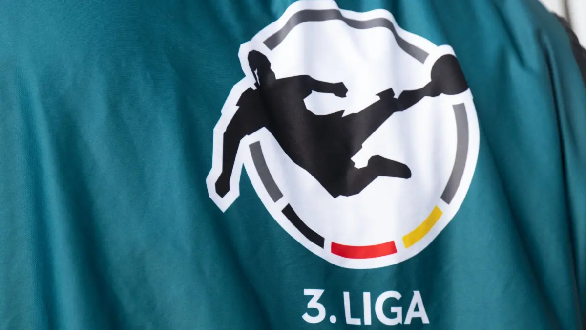 3. Liga: ARCHIV - 04.10.2023, Sachsen, Dresden: Fußball: 3. Liga, SG Dynamo Dresden - Hallescher FC, 9. Spieltag, Rudolf-Harbig-Stadion. Ein Mitarbeiter der Fernsehproduktion trägt ein Leibchen mit dem Logo der 3. Liga. Würzburg und Hannover II spielen in der Relegation gegeneinander. (zu dpa: «Fortuna Köln kehrt nach sieben Jahren in die 3. Liga zurück») Foto: Robert Michael/dpa +++ dpa-Bildfunk +++