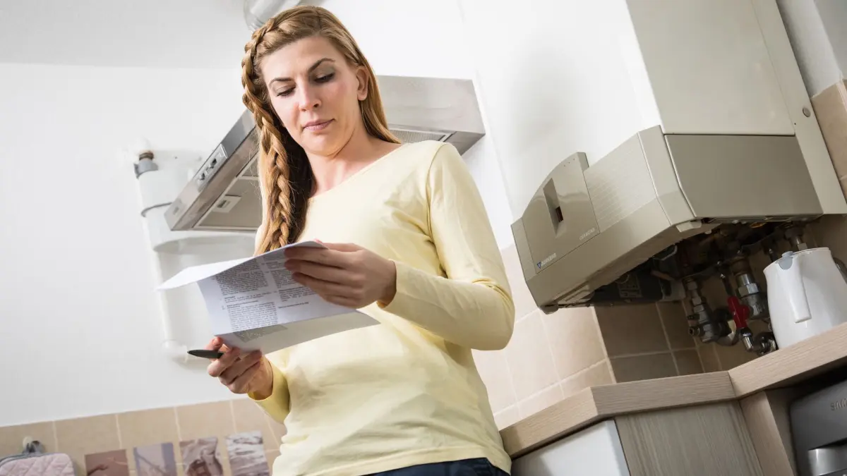 Frau liest Brief zum Anbieterwechsel eines Energieversorgers: ILLUSTRATION - Immer eine gute Idee: Den eigenen Gastarif regelmäßig prüfen und vielleicht zu einem günstigeren Anbieter wechseln. (zu dpa: «Ein Euro kommt zum anderen: Geldfresser im Alltag aufspüren») Foto: Christin Klose/dpa-tmn - Honorarfrei nur für Bezieher des dpa-Themendienstes +++ dpa-Themendienst +++