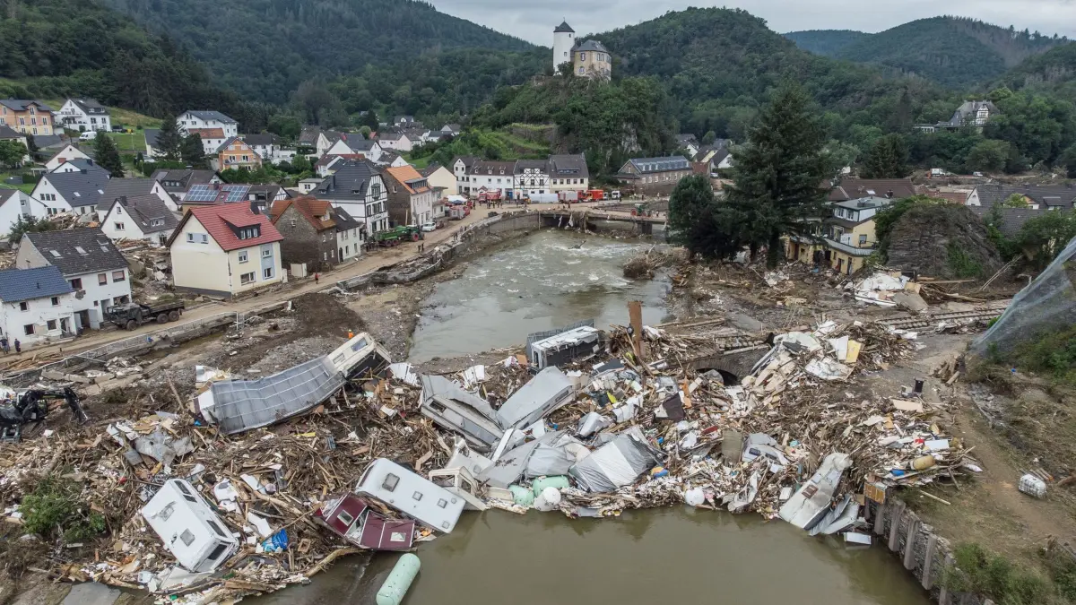 Ahrtal-Flut: ARCHIV - 19.07.2021, Rheinland-Pfalz, Altenahr-Kreuzberg: Meterhoch türmen sich wenige Tage nach der Flutkatastrophe Wohnwagen, Gastanks, Bäume und Schrott an einer Brücke über die Ahr in Altenahr-Kreuzberg (Luftaufnahme mit einer Drohne). (zu dpa: «Dreharbeiten zur ARD-Serie über Flut im Ahrtal gestartet») Foto: Boris Roessler/dpa +++ dpa-Bildfunk +++